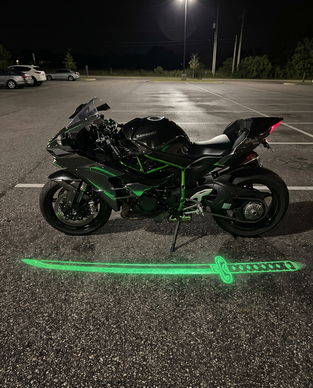 KataGlow green katana light projected on the ground beside a black sportbike at night